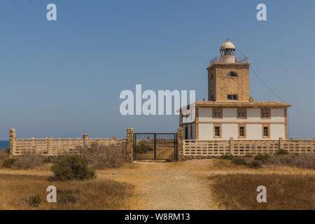 Un faro alla fine di una strada in una popolare destinazione turistica dell'isola di Tabarca nei pressi di Alicante in Spagna Foto Stock