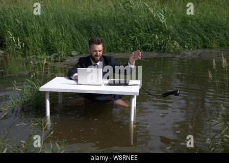 Stanco, depresso, noioso, imprenditore barbuto prende il telefono, deluso con una transazione non riuscita o cattive notizie Foto Stock