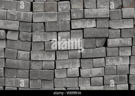 Mattoni pietre per pavimentazione posata su pallet, texture di sfondo di close-up. Acciottolato Pavimentazione strade, materiali per costruzione e decorazione di strade di città Foto Stock