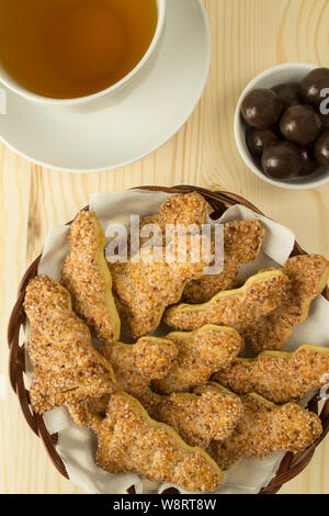 Una tazza di tè con biscotti di zucchero sotto forma di un nuovo anno di albero con cannella e cioccolato di confetti, caramelle dessert che serve, verticale vista superiore Foto Stock