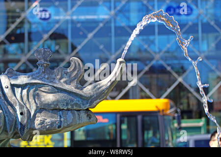 Copenaghen, Danimarca - testa di drago sputa acqua con sfocate sullo sfondo della città. Dettaglio del drago fontana in Radhuspladsen , gruppo bronzeo costruito nel Foto Stock