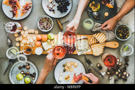 Salumi e formaggi, vino rosato, spuntini e i popoli mani Foto Stock