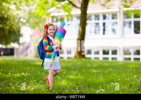 Bambino felice azienda tedesca tradizionale cono candy sul primo giorno di scuola. Piccolo studente con zaino e libri entusiasti di tornare a scuola. Beginn Foto Stock