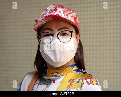 Vestite cinese tailandese donna indossa la fantasia LA cappello da baseball, occhiali di protezione monouso per la maschera per il viso, durante il Capodanno cinese 2019. Foto Stock