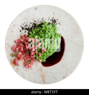 Gli spinaci risotto con tonno crudo filetto e teriyaki nella piastra di marmo, isolato su bianco Foto Stock