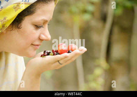 Giovane donna maleodoranti maturano a primavera tempo prugne odore in mano, mangiare sano concetto Foto Stock