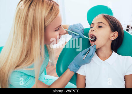 Bambina di ottenere denti esame dal dentista pediatrico in cliniche Foto Stock