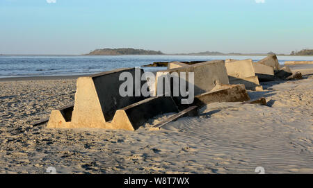 Blocchi in calcestruzzo usato per formare una struttura di frangionde all'estremità sud di Tybee Island Georgia, memorizzato su una spiaggia. Foto Stock