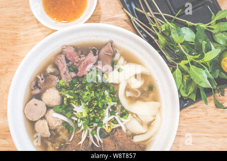 Special Beef pho vietnamita con zuppa e fette di manzo, punta di petto, palline di manzo, pesce maw, lo scalogno servito con erbe aromatiche Foto Stock