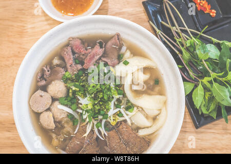 Special Beef pho vietnamita con zuppa e fette di manzo, punta di petto, palline di manzo, pesce maw, lo scalogno servito con erbe aromatiche Foto Stock