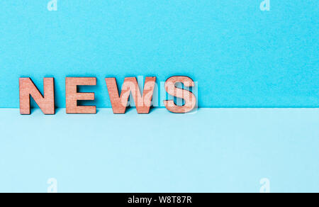 Parola notizie su un blu lettera in legno sfondo Foto Stock