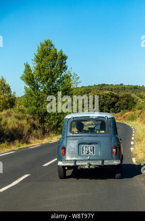 Classic Renault 4 TL auto guidando su una tranquilla strada francese Foto Stock