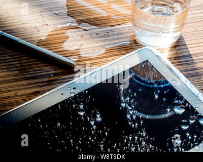 L'acqua versata sulla tavoletta, gocce di acqua sul tablet schermo Foto Stock