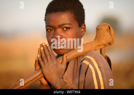 Giovane donna con una zappa in un remoto villaggio nei pressi di Dedza. Il Malawi è uno dei paesi più poveri del mondo. Foto Stock