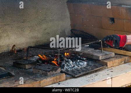 Incendio in un barbaque, l'impostazione di fuoco sul proprio grill a carbone Foto Stock