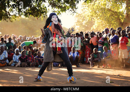 Nyau tradizionali ballerini con la maschera per il viso a un Gule Wamkulu cerimonia in remoto villaggio vicino Ntchisi. Il Malawi è uno dei paesi più poveri del mondo Foto Stock