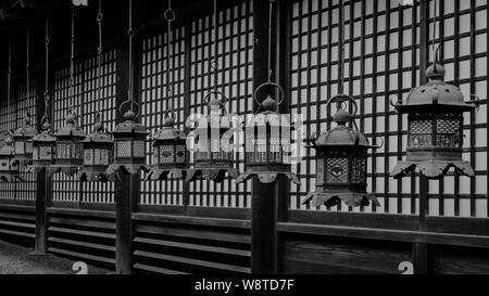 Gruppo di tradizionali lanterne di bronzo appesa al tetto del Santuario edificio principale in Naras Kasuga Taisha offrendo un pattern, Giappone Novembre 2018 Foto Stock