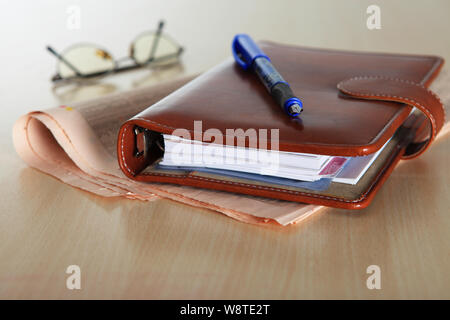 Personal organizer and pen on a financial newspaper Stock Photo