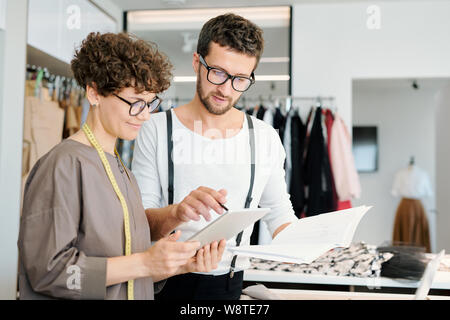 Piuttosto giovane femmina sarto e il suo collega per discutere di nuove idee Foto Stock