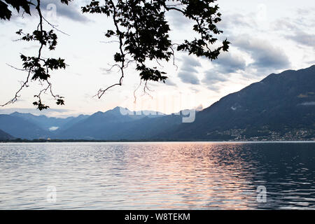 Estate tramonto lungo il Lago Maggiore nella città di Locarno nella regione italiana del Canton Ticino in Svizzera. Foto Stock