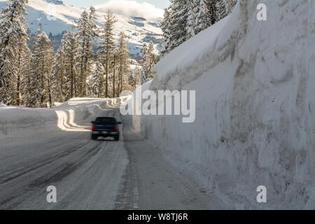 Unidentified muovendo il veicolo sulla strada di montagna autostrada 88 verso Carson Pass, California, Stati Uniti d'America, in un giorno di inverni dotato di cinque metri di neve sul lato Foto Stock