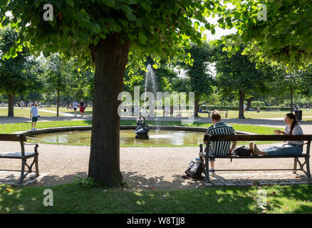 Parco di Copenaghen; persone relax su una soleggiata giornata d'estate in agosto a Kongens Have ( Re garden ), centro di Copenaghen, il Copenhagen DANIMARCA Foto Stock