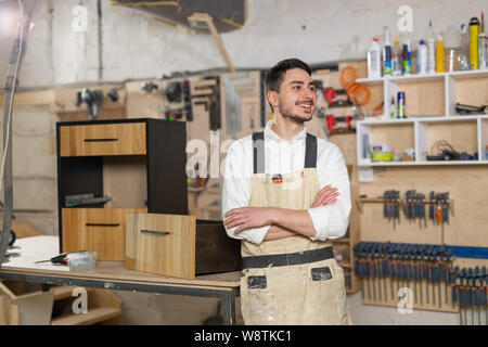 Mobili fabbrica, piccole aziende e persone concetto - Ritratto di un sorridente lavoratore di sesso maschile in fase di fabbricazione Foto Stock