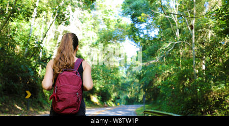 Donna di viaggiatori con zaino camminando sul percorso di foresta tropicale in Brasile Foto Stock