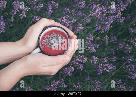 Mani lavanda sani tazza da tè. Vista superiore, Lavanda fiori sullo sfondo. Foto Stock