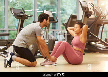 A piena lunghezza Ritratto di mixed-gara giovane lavorando insieme in palestra, spazio di copia Foto Stock