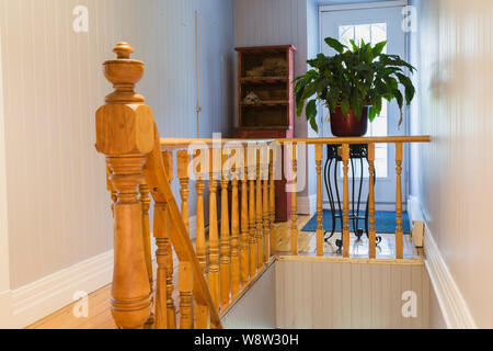 Pineta post e una scalinata che conduce al piano di sotto pavimento all'interno di un vecchio 1820 cottage in stile fieldstone house Foto Stock