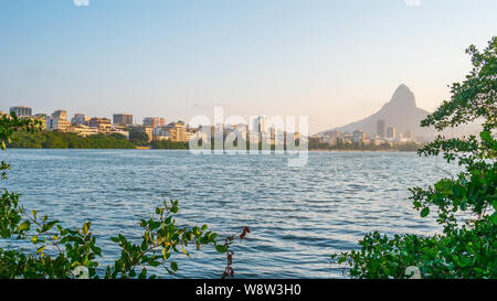 Vista panoramica (16x9) paesaggio della laguna Rodrigo de Freitas a Rio de Janeiro compresi Dois Irmaos Mountain e alcune facciate di edifici Foto Stock