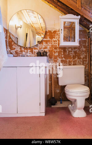 Esposto un muro di mattoni durante i lavori di ristrutturazione nel bagno principale sul pavimento del piano superiore all'interno di un vecchio 1820 in stile cottage di pietra da taglio e fieldstone house Foto Stock