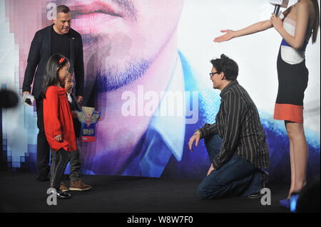 Attore americano Johnny Depp, seconda a destra, si mette in ginocchio per salutare due giovani bambini in occasione di una conferenza stampa per il suo film, trascendenza, a Pechino, in Cina, 3 Foto Stock