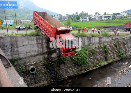 Un carrello è penzolante fuori di una sporgenza dopo un incidente su una strada in città Jiachuan, Wangcang county, città Guangyuan, southwest Chinas nella provincia di Sichuan, 1 Foto Stock