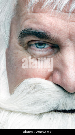 Close-up di un volto di Santa Claus. Bianco-dai capelli uomo anziano con barba e baffi cercando nella fotocamera. Foto Stock