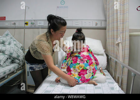 12-anno-vecchia ragazza Han Bingbing, destra, che soffre di un tumore gigante nel suo ventre è frequentato da sua madre al cancro Fuda ospedale nella città di Guangzhou, Foto Stock