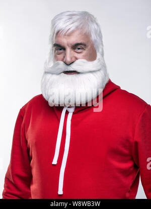 Ritratto di una Santa Claus in sportsware. Bianco-dai capelli uomo anziano con barba e baffi cercando nella fotocamera. Foto Stock