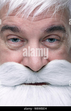 Close-up di un volto di Santa Claus. Bianco-dai capelli uomo anziano con barba e baffi cercando nella fotocamera. Foto Stock