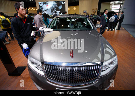 --FILE--un dipendente pulisce un Hongqi (bandiera rossa) H7 di FAW durante il XIII Beijing International Automotive Exhibition, noto anche come Auto China 2014, ho Foto Stock