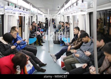 --FILE--cinese i passeggeri seduti in un treno della metropolitana di Pechino linea 10 in corrispondenza di una stazione della metropolitana di Pechino, Cina, 29 gennaio 2014. Beijing Municipal aut Foto Stock