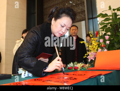 Cinese cantante folk Peng Liyuan, moglie di cinese poi Vice Presidente Xi Jinping, scrive la calligrafia in occasione di una cerimonia che si terrà per la prima la Cina Arts Awards in B Foto Stock