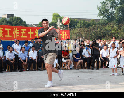 Pensionato cinese superstar di basket Yao Ming mostra la sua abilità di basket per gli studenti di una scuola primaria per promuovere Yao Foundation speranza Progetto in Sh Foto Stock
