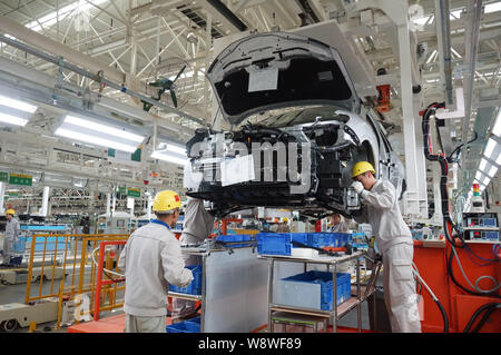 --FILE--lavoratori cinesi assemblare un auto sulla linea di montaggio presso l'impianto automatico di Dongfeng Nissan Dalian Branch Company di Dongfeng Motor Co. Ltd, Foto Stock