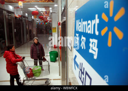 --FILE--i clienti lasciano un supermercato Walmart nella Città di Zhengzhou, porcellane centrale provincia di Henan, 24 gennaio 2014. Un lavoro cinese unione e quattro per Foto Stock