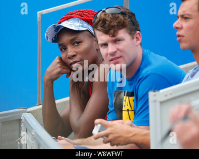 American la stella del tennis Venus Williams, sinistra, orologi la sua sorella più giovane Serena Williams ha ricevuto il trattamento come Serena compete contro Alize Cornet di F Foto Stock