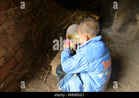 Le otto-anno-vecchio infetti da HIV boy Kun Kun mangia la tagliatella nella sua casa di villaggio Liqiao, Xicong county, città di Nantong, a sud-ovest della Cina di Sichuan Foto Stock