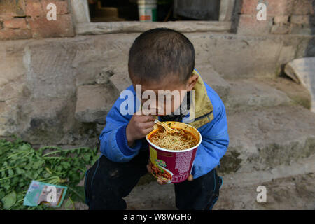 Le otto-anno-vecchio infetti da HIV boy Kun Kun mangia la tagliatella nel villaggio Liqiao, Xicong county, città di Nantong, a sud-ovest della Cina di provincia di Sichuan, 21 Foto Stock