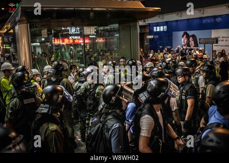 Hong Kong arresto di polizia civili e passanti di fronte la stazione MTR sulla Nathan Road, durante le dimostrazioni.gli agenti di polizia e manifestanti si scontrano in Nathan Road in Tsim Sha Tsui. Un totale di 35 persone sono state arrestate quando i dimostranti hanno preso la strada per dimostrare contro il governo, chiedono il ritiro completo della legge in materia di estradizione e per il governo di istituire un' inchiesta indipendente sui recenti scontri tra il manifestante e forze di polizia. La polizia ha sparato gas lacrimogeni in risposta a un altro fine settimana di proteste. Foto Stock