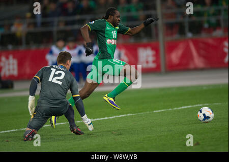 Maduabuchi Peter Utaka di porcellane Guoan Pechino, destra dribbling passato portiere Liam Rhys Reddy di Australias Central Coast Mariners durante il loro Grou Foto Stock